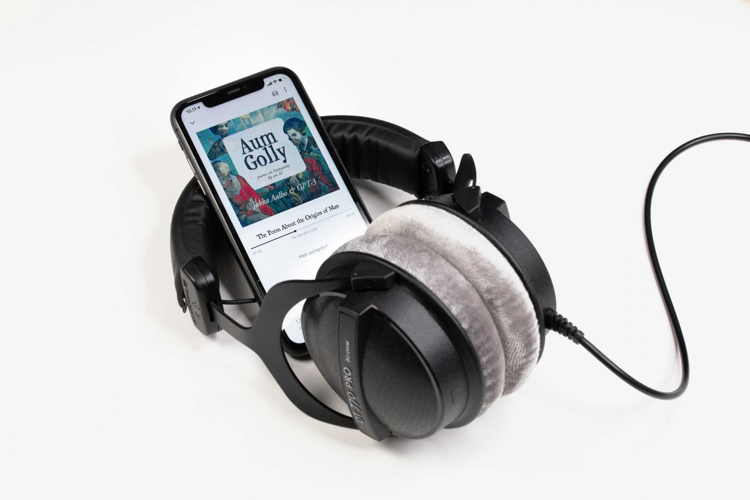 jukka-aalho-6pV3qV4HRVw-unsplash Phone with audiobook on screen surrounded by headphones