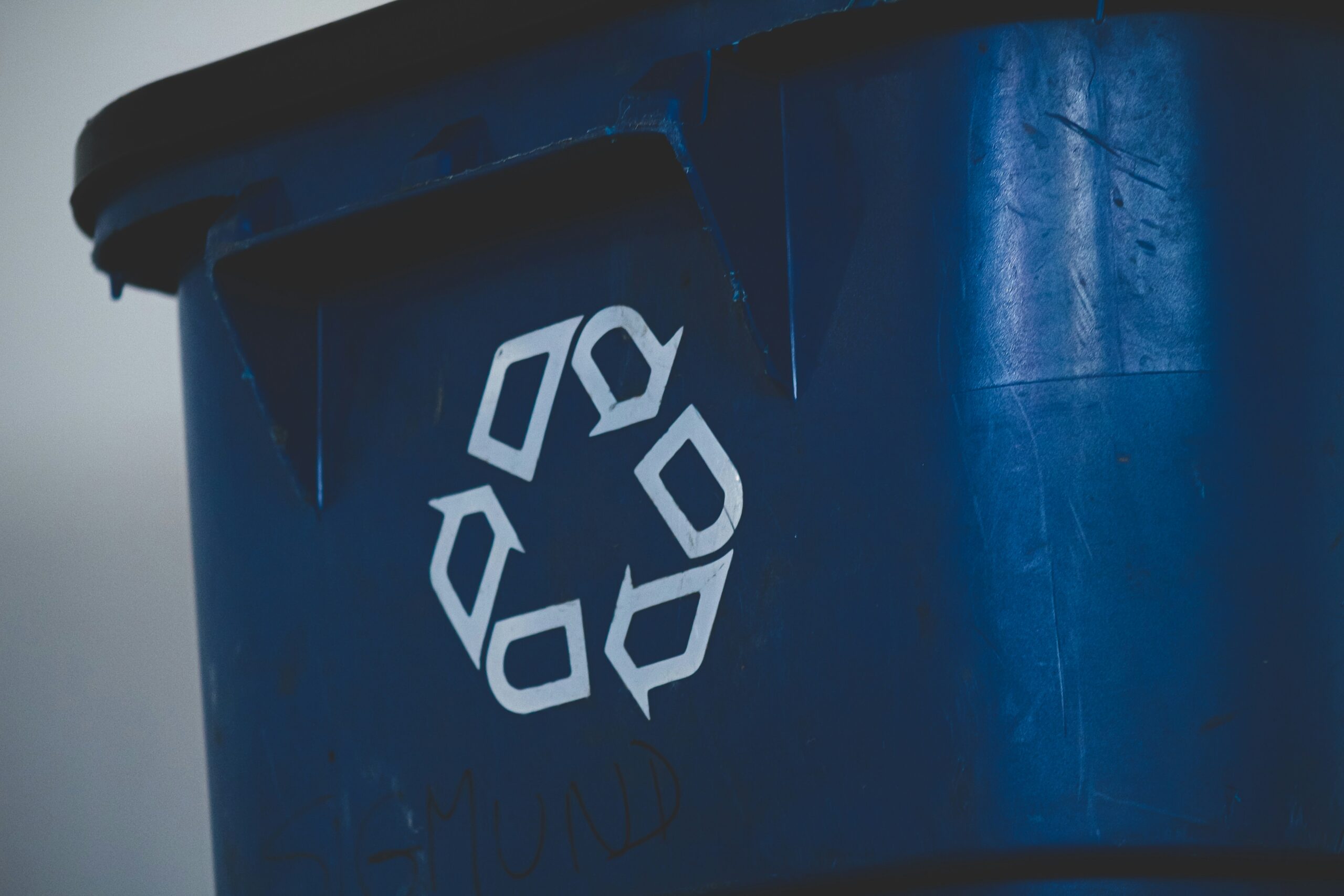 Blue bin with recycling symbol on it.