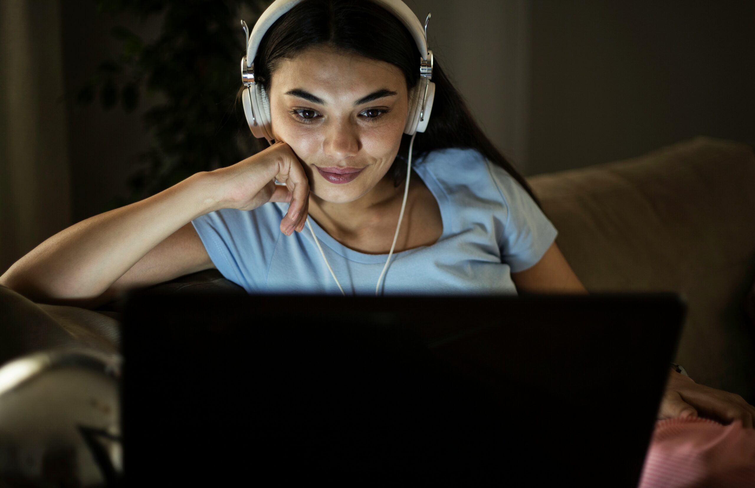 getty-images-exABUVLmoYU-unsplash Woman wearing headphones in front of laptop at night